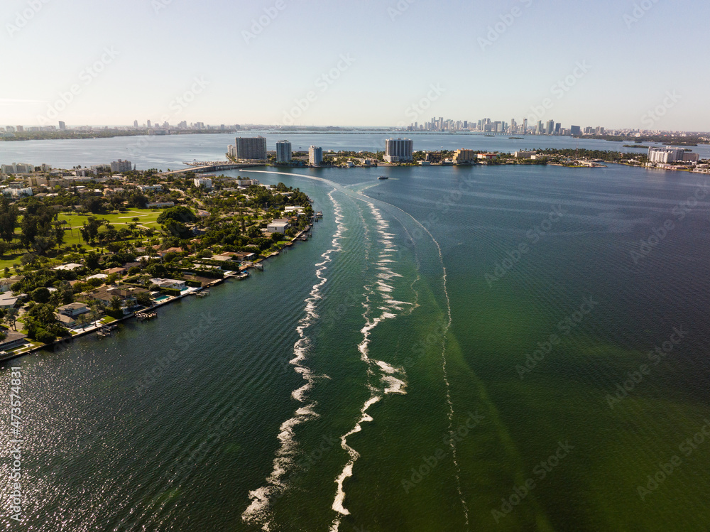 boat trails in the bay of miami beach showing many buildings