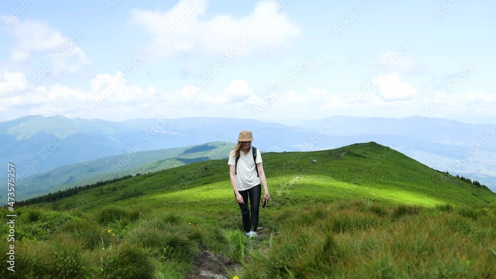 Happy female tourist with a travel backpack climbs a mountain stone path high in the Carpathian hills. Ukraine. Happy female tourist with a travel backpack climbs a mountain stone path high in the Carpathian hills. Ukraine.