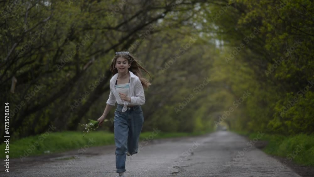 fashionable little girl walking on the village road branchy trees fashionable little girl walking on the village road branchy trees