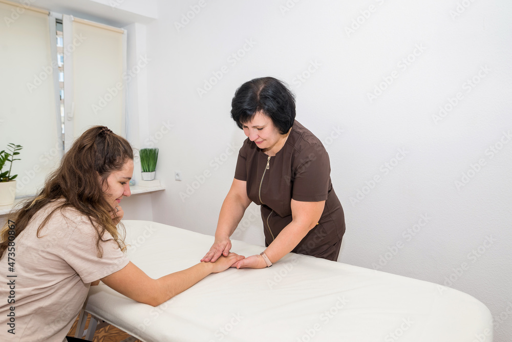 Fototapeta premium Female masseuse doing wrist massage