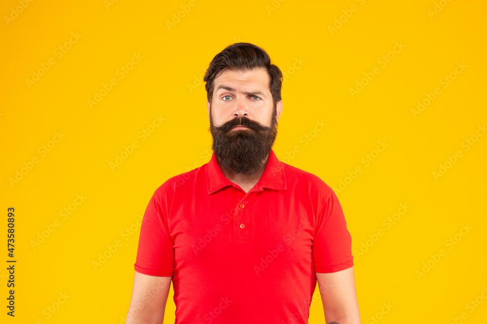 serious bearded man with moustache in tshirt on yellow background, face serious bearded man with moustache in tshirt on yellow background, face
