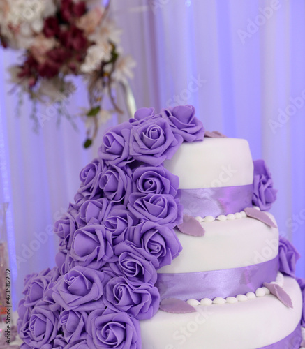 Wedding cake decorated with purple rose flowers