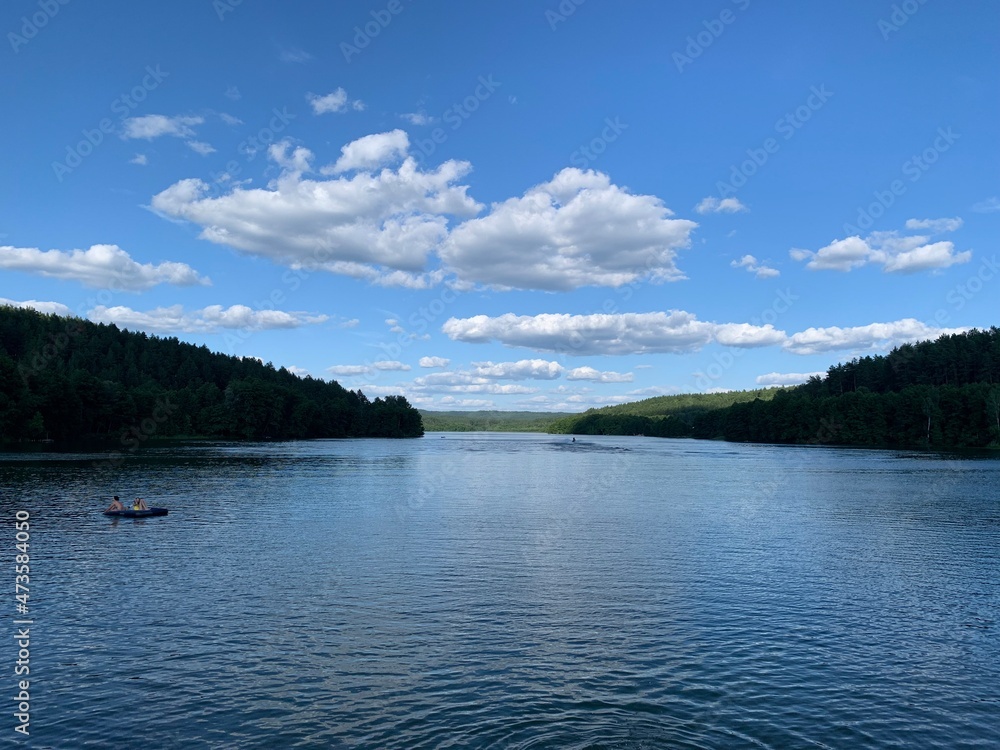 the calm expanse of Lake Yulovskoe surrounded by forest and greenery in summer