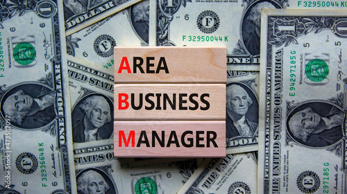 ABM area business manager symbol. Concept words ABM area business manager on wooden blocks. Beautiful background from dollar bills, copy space. Business and ABM area business manager concept.