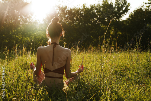 woman in summer sitting on the grass outdoors meditation freedom