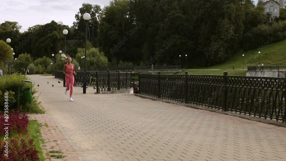 blond hair girl running in the park with headphones and smile blond hair girl running in the park with headphones and smile