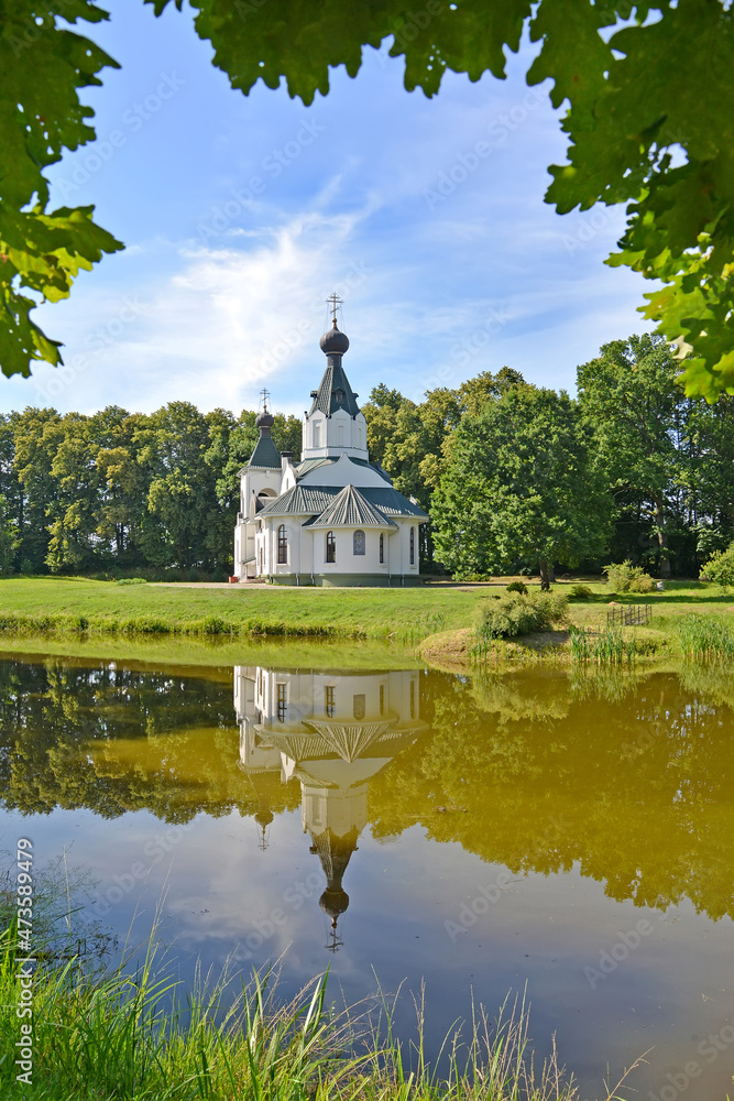 Summer landscape with a view of the Church of the Sovereign Icon of the Mother of God. Izobilnoe village, Kaliningrad region Summer landscape with a view of the Church of the Sovereign Icon of the Mother of God. Izobilnoe village, Kaliningrad region