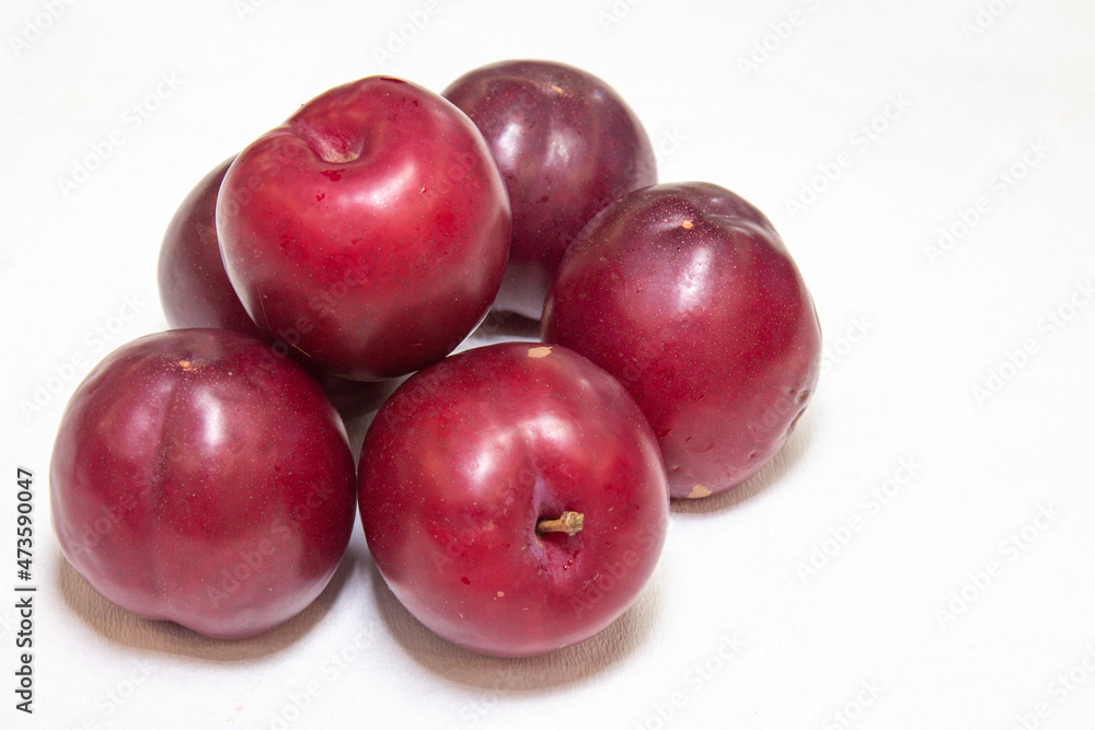 Ripe plum group on white background and selective focus