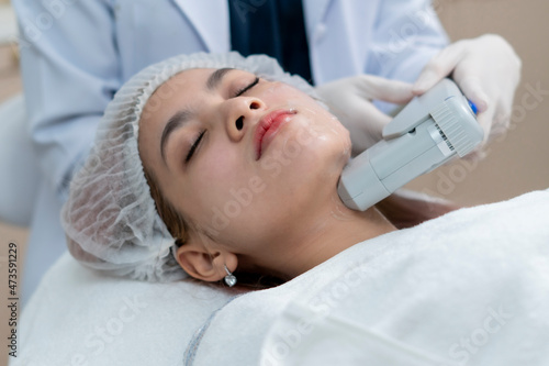 Close up the dermatologist apply the High intensity focus ultrasound to the woman face  for the facial treatment  rejuvenation and anti-aging.