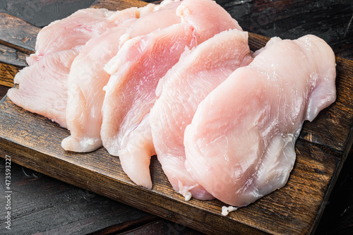 Raw chicken meat, on old dark wooden table background