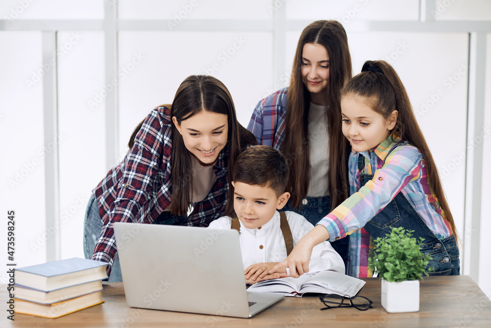 Group of kids of different ages together work on homework helping each other. Group of kids of different ages together work on homework helping each other.
