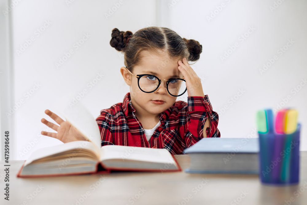 Little girl wearing glasses and doing homework. Little girl wearing glasses and doing homework.