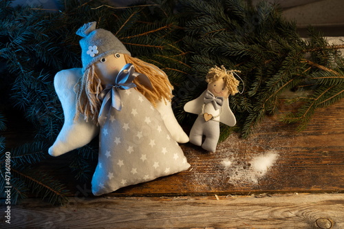 Festive decoration for Christmas. Plush Angels on old boards and spruce branches.
