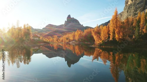 Drone flyght over Federa Lake in sunrise time. Autumn mountains landscape with Lago di Federa and bright orange larches in the Dolomite Apls, Cortina D'Ampezzo, South Tyrol, Dolomites, Italy
