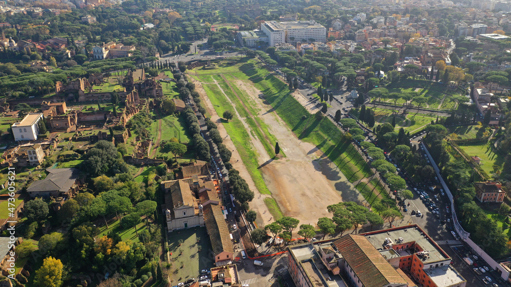 Aerial drone photo of iconic Circus Maximus a green space and remains of a stone - marble arena used for chariot races built next to Palatine hill and world famous Colosseum, historic Rome, Italy