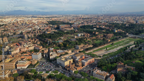 Aerial drone photo of iconic Circus Maximus a green space and remains of a stone - marble arena used for chariot races built next to Palatine hill and world famous Colosseum, historic Rome, Italy