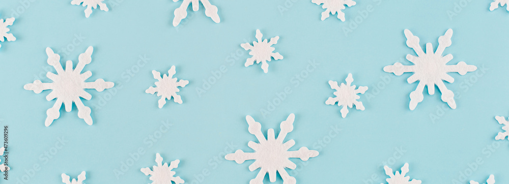 Christmas composition. Banner made of snowflakes on blue background. Christmas, winter, new year concept. Minimal style. Flat lay, top view Christmas composition. Banner made of snowflakes on blue background. Christmas, winter, new year concept. Minimal style. Flat lay, top view