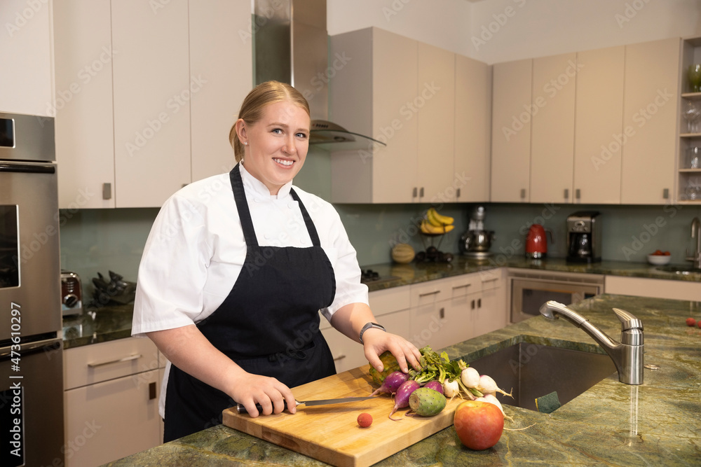 Portrait of Chef Megan Gill in home kitchen looking at camera smiling with pride. Portrait of Chef Megan Gill in home kitchen looking at camera smiling with pride.