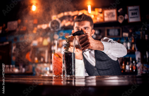 Young tapster makes a cocktail in cocktail bars