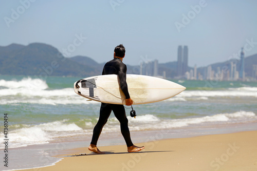 surfer goes riding waves in Brazil. Surfing action water board sport. Men catching waves in ocean, isolated. Young people sports lessons and beach activity on summer vacation