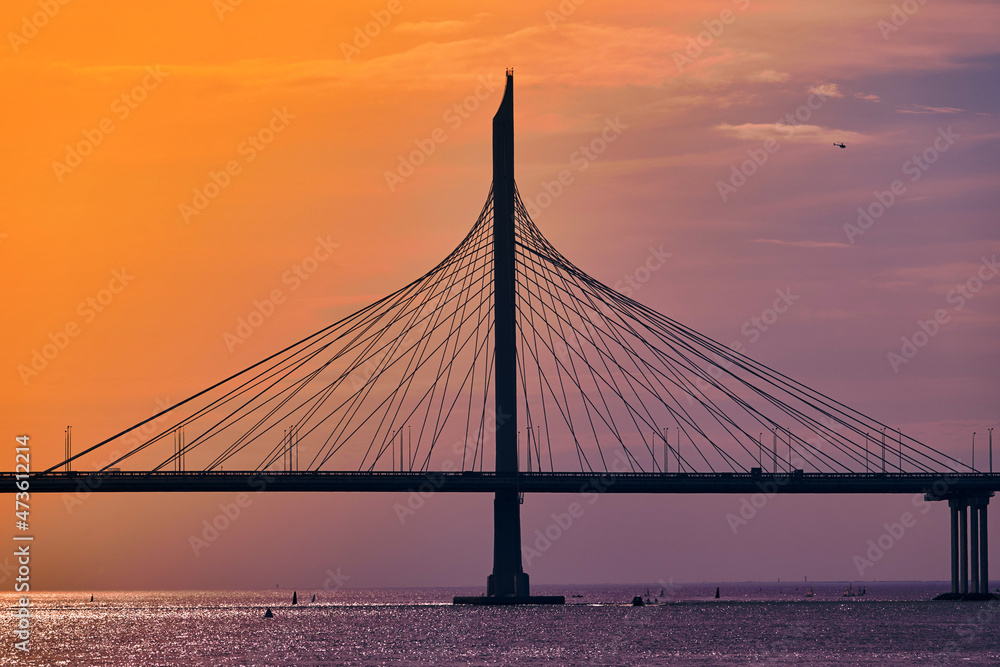 Obraz premium Cable-stayed bridge over the river at sunset. Water landscape.