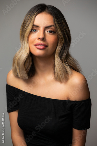 Beauty portrait of Hispanic woman looking into camera on gray background photo