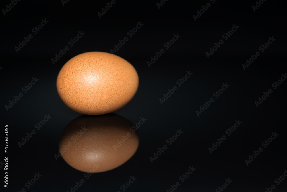 Natural yellow chicken egg on a black background Natural yellow chicken egg on a black background