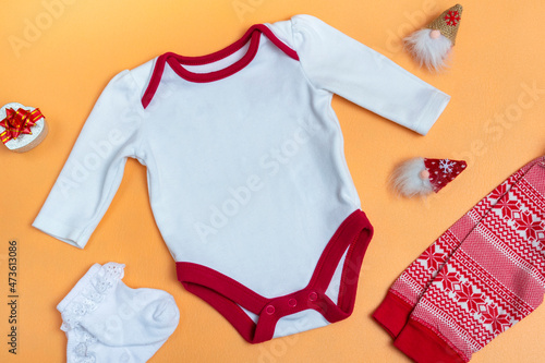 Mockup of a white baby bodysuit on a colored background close-up with red pants and gnomes mockup of clothes for newborns. With copy space
