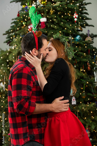 Young couple kissing under Christmas tree. photo