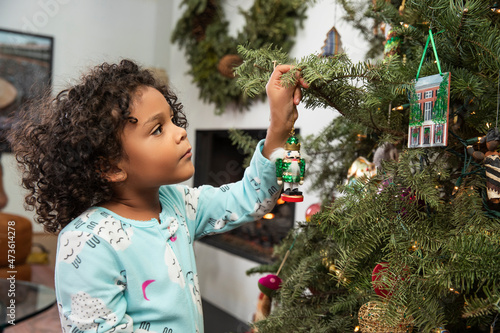 Little girl decorating Christmas tree. photo