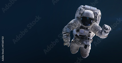 Astronaut floating and isolated on dark background. Spaceman sci-fi space wallpaper. Elements of this image furnished by NASA
