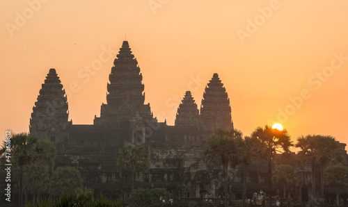 The sun rises beside the temple of Angkor Wat.