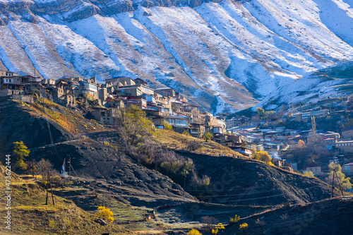 Chokh village close up, Dagestan, Russia. Panoramic view of the village Chokh on the backdrop of snowy mountains. Historic houses and streets on slopes photo