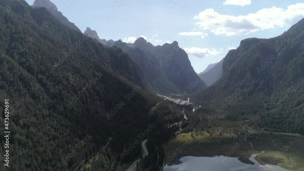 Aerial Scenic Shot Of Forest On Green Mountains, Drone Flying Forward Over Lake - Dolomites, Italy Aerial Scenic Shot Of Forest On Green Mountains, Drone Flying Forward Over Lake - Dolomites, Italy