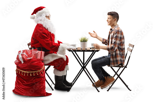 Santa Claus sitting at a table and listening to a young man talking and gesturing with hand