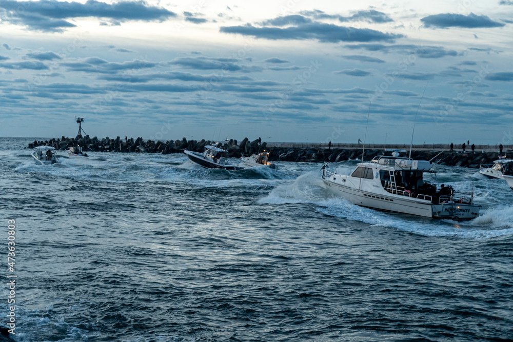Naklejka premium Sport Fishing boats racing out to sea at sunrise 