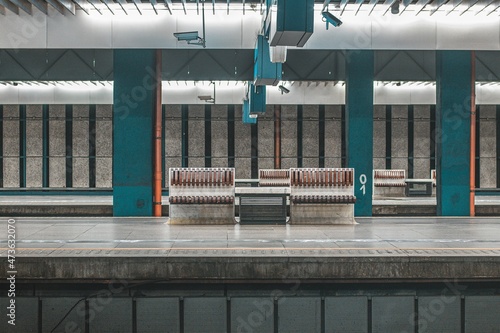 Empty train platform at Warsaw Centralna train station. Visible benches for passengers, pillars and platforms. Modernistic photo.