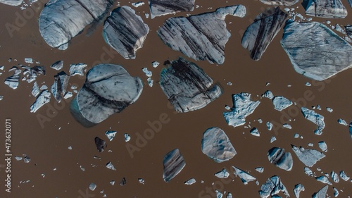 Bick blocks of glacier ice broken from big glacier at hoffell, iceland, floating in brown water.ž photo