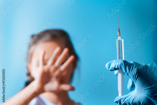 The child was given a vaccine.Female doctor or nurse trying to give shot or vaccine against virus to a scared patient. Angry and distrustful patient refuses to receive it.