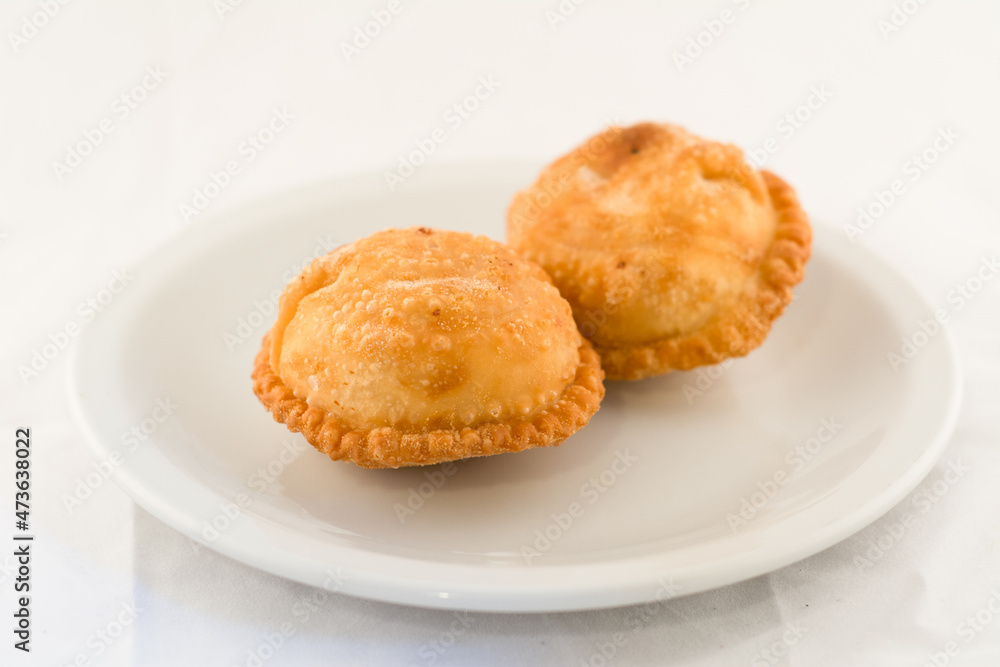 dos tartas de masa rellena fritas en plato blanco dos tartas de masa rellena fritas en plato blanco