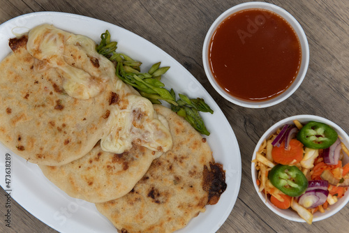 Canvas Print Overhead view of three round pupusas served with salsa and dipping sauce as a La