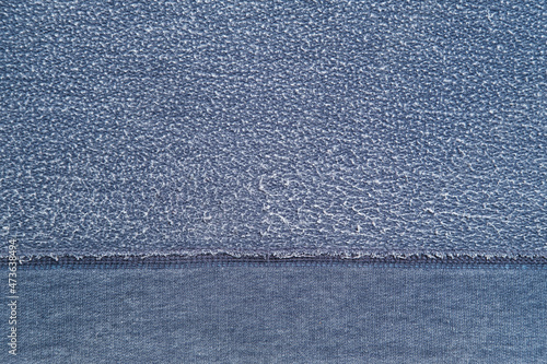 Pellets on textured blue fabric background. Reverse side of old clothes with white roll. Copy space. Top view. 