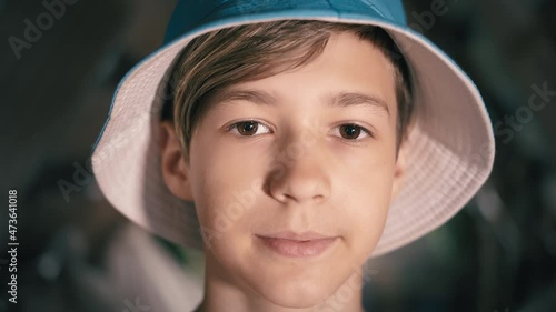 portrait of a happy teen boy in a hat looking at the camera, teen boy 12 years old, cinematic shot photo