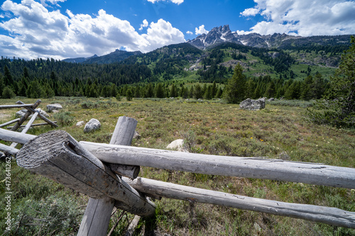 Fototapeta Naklejka Na Ścianę i Meble -  Rustic fence with the Grand Teton mountain range in the background in Wyoming USA during summer on a sunny day