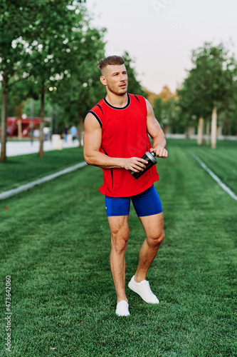 athletic man in red tank top posing outdoors fitness © VICHIZH