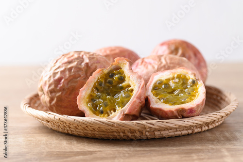 Overripe passion fruit in basket on wooden table