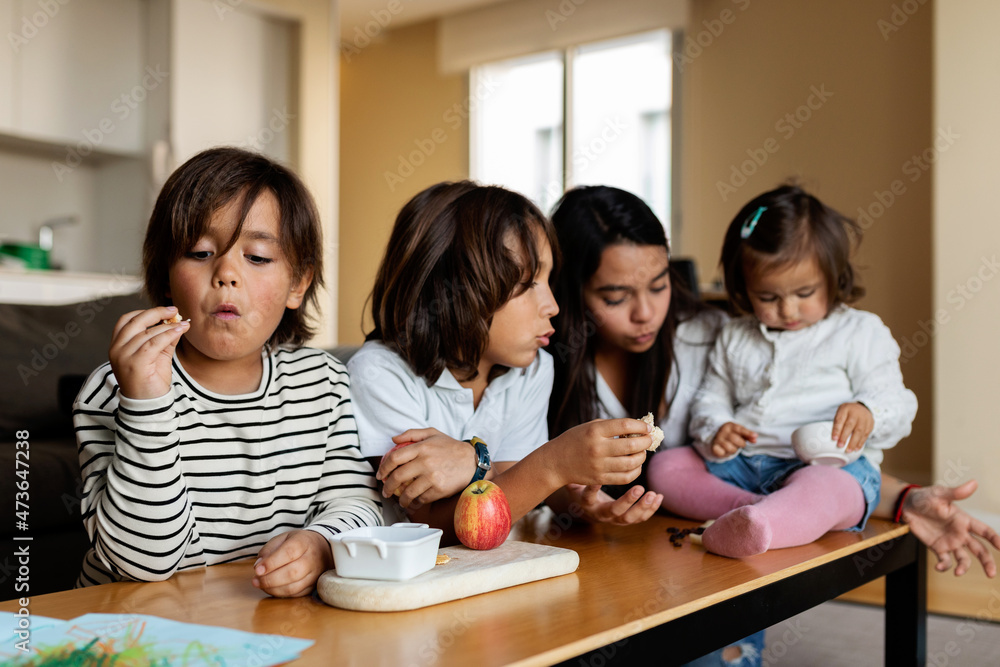 Siblings eating snack at home Siblings eating snack at home