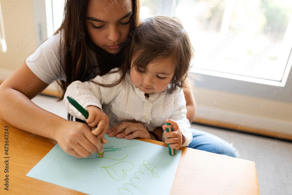 Babysitter helping the baby girl to draw at home Babysitter helping the baby girl to draw at home