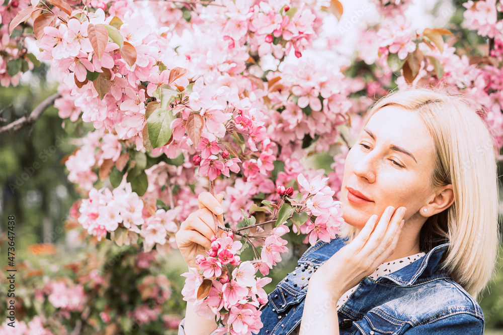 Young woman among the blossoming trees. Spring nature park or garden, flowering trees. Concept spring woman health Young woman among the blossoming trees. Spring nature park or garden, flowering trees. Concept spring woman health