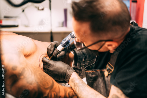 Tattoo artist working at his studio photo